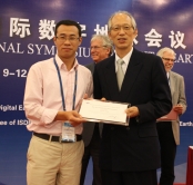 Dr. Jiang (left) receives the Best Youth Oral Presentation Award from Professor Shunji Murai (right) of the Organizing Committee