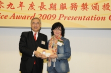 Prof. Lawrence J. Lau presents a certificate and a gold lapel pin to Mrs. Chan Tsoi Yuk-yin, recipient of 25-year Long Service Award