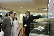 Prof. Tang Chung (right) showing the exhibits to Prof. and Mrs. Yang Chen Ning