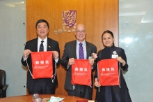 Prof. Emily Y. Y. Chan (left) presents CCOUC rescue bags as souvenir to Prof. Joseph J. Y. Sung, (right) and Prof. Andrew Hamilton.