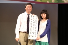 Professor Sung presents his calligraphy to a lucky draw winner.