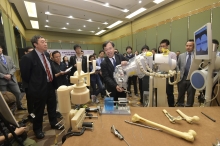 Prof. Leung Kwok Sui, Professor, Department of Orthopaedics and Traumatology, CUHK (middle) demonstrates the Hybrid Orthopaedic Robot which has been successfully applied in more than 10 orthopaedic surgeries.