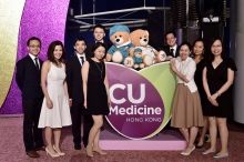 Guests take photo in front of the Faculty logo with medic and surgeon bears.