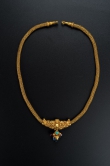 Gold Necklace with Makara Design
Northern dynasties or earlier, 2nd to 6th century
Length 47 cm, pendant length 4.4 cm, weight 119.9 g (complete)
Mengdiexuan collection
This exquisite necklace comprises a chain with conical ends capped by a circular loop, and a pendant. The loop-in-loop chain is made of eight interwoven gold wires and connected to the pendant with gold nails. The pendant is intricately worked to form a human figure with a depression in the middle of the forehead that resembles a ‘third eye’. The figure has a big belly and holds two makaras by their tails as they bite the ends of the chain. Suspended from below his belly is a second pendant in the form of a lower inlaid with red, blue and green gemstones, adding colour to an already luxurious gold ornament.