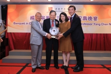 中大校董會主席梁乃鵬博士(左一)和校長沈祖堯教授(右一)代表中大致送白玉平安扣，祝願楊教授福如東海，壽比南山。