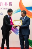 Professor Tuan presents certificates to a student.