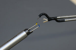 In a conventional manual ERBT procedure, urologists resect tumours with the built-in knife equipped in the cystoscope (left). Since the instrument only has one arm, resection can only be performed from a single angle and direction, resulting in limitation of dexterity. <br />
The locally developed endoscopic surgical robotic system with fully flexible robotic arms (right) comes with a pair of flexible and compact robotic instruments to achieve tissue retraction and dissection. Each instrument can move in more than five different directions and enable en bloc tumour resection within a tiny space.