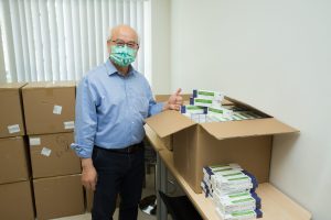 Prof. CHAN Kwok Hong Raymond, University Dean of Students, receives the donation of test kits.