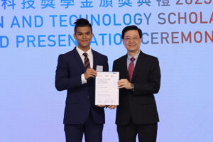 Chief Executive Mr John Lee (right) presents the Innovation and Technology Scholarship to Lam Kin-hang (left).