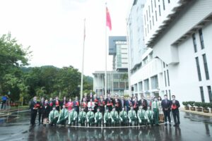 The University officers and guests pose for a group photo with the flag-raising team.