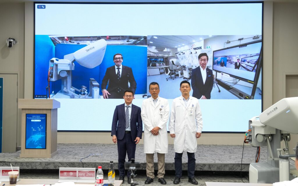中大醫學院與上海和英國倫敦的頂尖外科團隊橫跨歐亞三地，成功同步進行手術機械人輔助的手術。中大醫學院院長、信興教育及慈善基金機械人外科教授趙偉仁教授（後排右）、負責手術的倫敦團隊成員、倫敦皇家馬斯登醫院顧問醫生Asif Chaudry教授（後排左）與身處上海的嘉賓及手術團隊中大機械與自動化工程學系兼中大醫療機械人創新科技中心聯合主任歐國威教授（前排左）、上海仁濟醫院團隊成員副院長王爭教授（前排中）；以及負責手術的上海團隊成員，上海仁濟醫院胃腸外科行政主任張子臻教授（前排右）合照。
